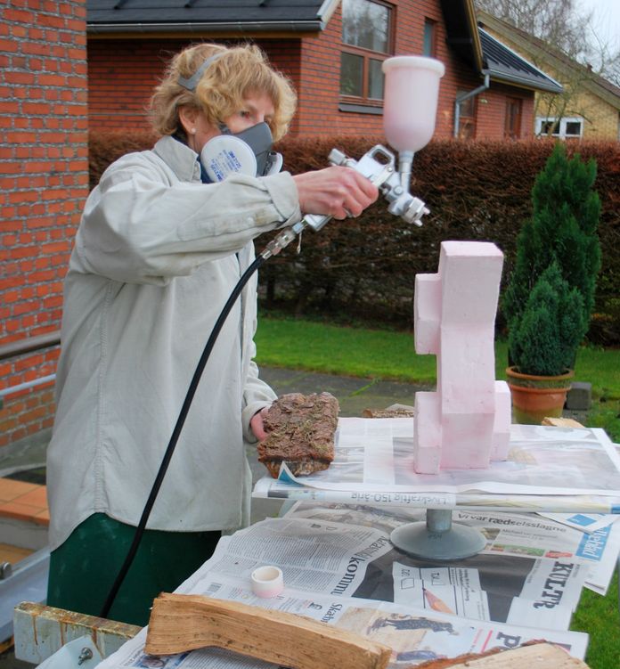 Kate arbejder med glasering af keramik med sprøjtepistol
